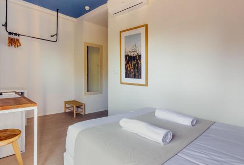 a white bedroom with a bed and a table at YOU & CO. Saler Beach Boutique in Valencia
