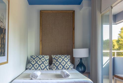 a bed with two pillows and a window in a room at YOU & CO. Saler Beach Boutique in Valencia