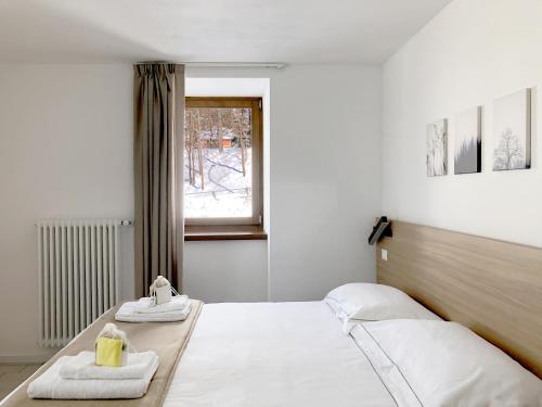 a bedroom with two beds and a window at Residence Aurora in Lavarone