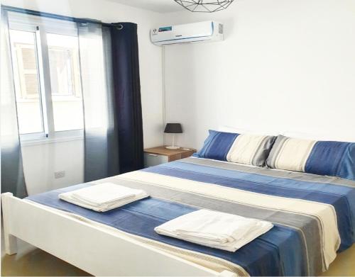 een slaapkamer met een bed met handdoeken erop bij Secondhome102 in Paphos City