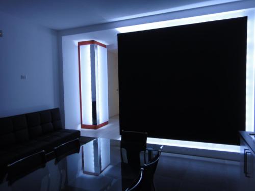 a living room with a black couch and a television at Villino Erminia - Seaside Art b&b in Pizzo