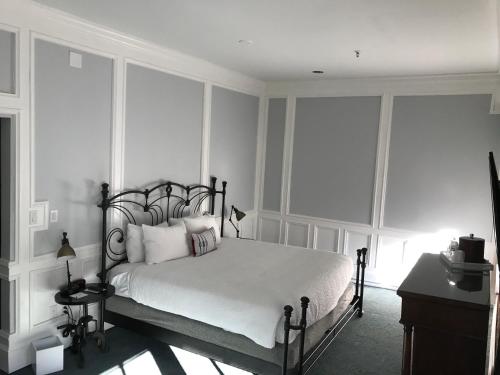 a bedroom with a bed with white sheets and pillows at River Street Inn in Savannah