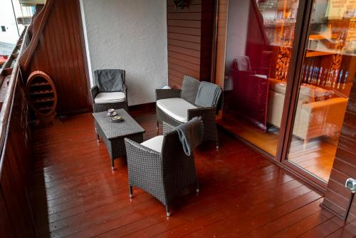 a balcony with wicker chairs and a table on a porch at Clabucet Nest DeLuxe Apartment in Predeal