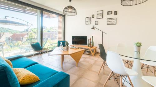 un salon avec un canapé bleu et une table dans l'établissement Open Sun avec Jacuzzi Privatif et parking privé, à Sarlat-la-Canéda