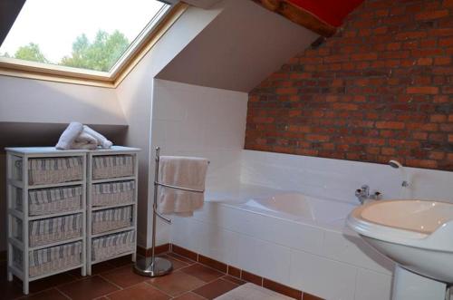 a bathroom with a toilet and a tub and a sink at Gîtes Ferme de la Barrière in Chimay