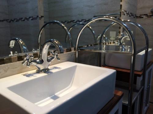 a bathroom with a sink and two mirrors at Residencial Victoria Said in Linares