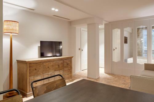 a living room with a television on a wooden dresser at Pamplonapartments Pozo Blanco in Pamplona