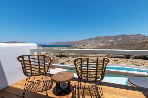 a balcony with two chairs and a swimming pool at Mykonos AG Villas in Ftelia Beach in Elia