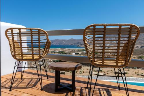 two rattan chairs and a stool on a balcony at Mykonos AG Villas in Ftelia Beach in Elia