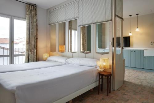 a bedroom with two beds and a large window at Pamplonapartments Pozo Blanco in Pamplona