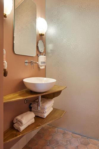 a bathroom with a sink and a mirror and towels at Pamplonapartments Pozo Blanco in Pamplona