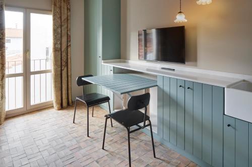 a kitchen with a table and two chairs and a tv at Pamplonapartments Pozo Blanco in Pamplona