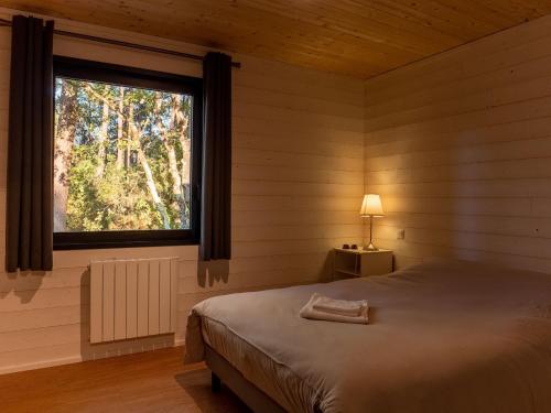 a bedroom with a bed and a large window at Lacanau Moutchic Inn in Lacanau