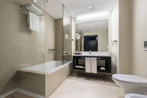 ein Badezimmer mit einer Badewanne, einem Waschbecken und einem WC in der Unterkunft Hotel Baia in Luanda