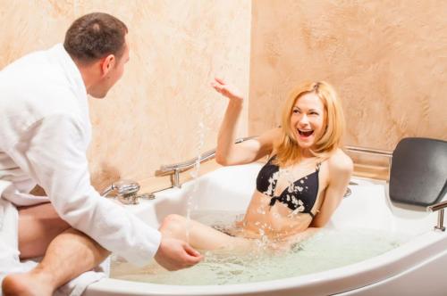 un hombre está lavando a una mujer en una bañera en Vyshegrad Castle Hotel, en Vyshgorod