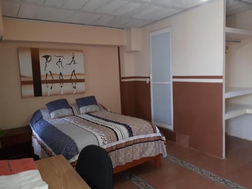 Un dormitorio con una cama y una mesa. en La Casa Azul Hostal y Pension - Coatepec, en Xalapa