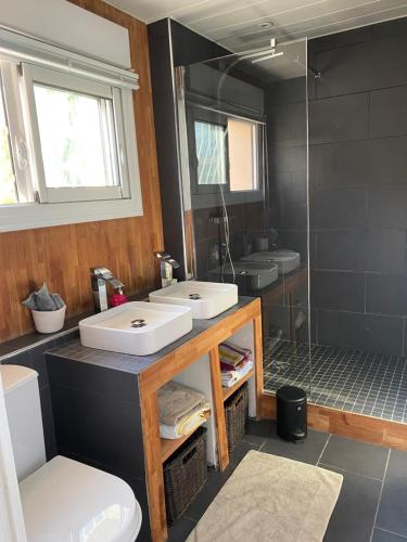 une salle de bain avec deux lavabos et une douche dans l'établissement Le murât, à Six-Fours-les-Plages