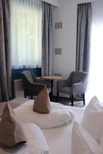 a hotel room with two beds and a table and chairs at Romantikhotel Residenz Wachau in Aggsbach Dorf
