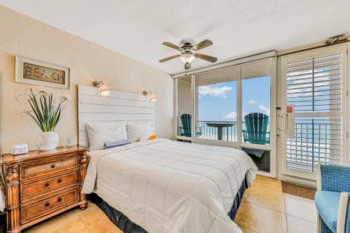 1 dormitorio con 1 cama y ventilador de techo en Sunshine & Oceanfront Serenity, en Daytona Beach Shores