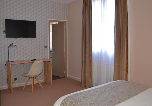 a bedroom with a bed and a desk and a chair at Logis Hotels - Château Saint Marcel in Boé