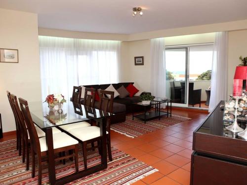 a living room with a table and a couch at Charming Lido Flat I in Funchal