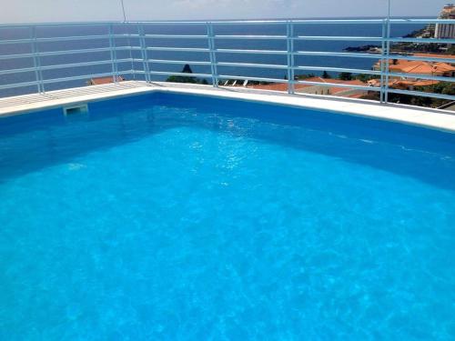 a large blue swimming pool on top of a building at Charming Lido Flat I in Funchal