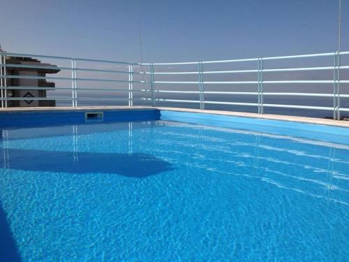 a swimming pool with a fence and blue water at Charming Lido Flat I in Funchal