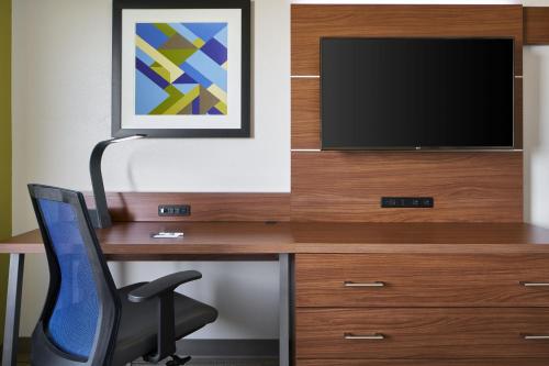 a desk with a television and a chair at Holiday Inn Express - Richmond Downtown by IHG in Richmond