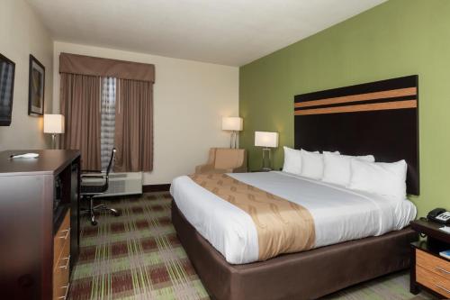 Habitación de hotel con cama grande y escritorio. en Quality Inn & Suites, en Mount Vernon