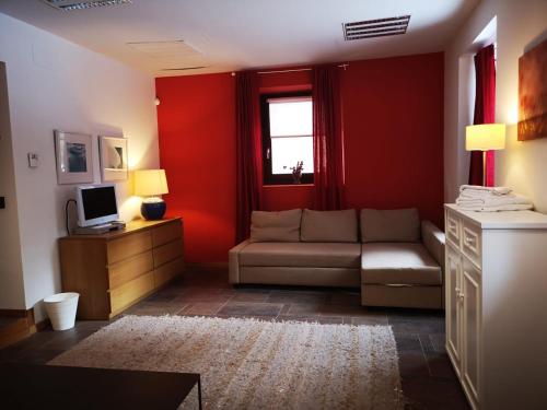 sala de estar con sofá y paredes rojas en Casa Rural Laguna Negra, en Vinuesa