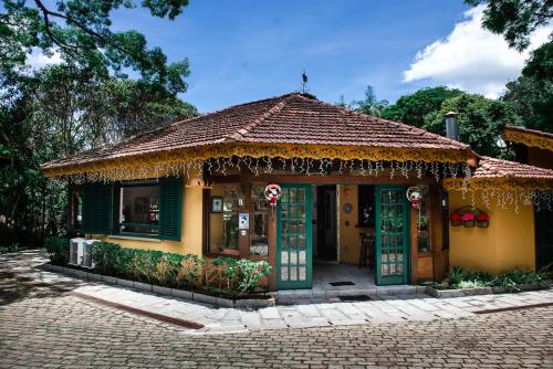 a small house with a tiled roof and green doors at Urikana Boutique Hotel in Teresópolis