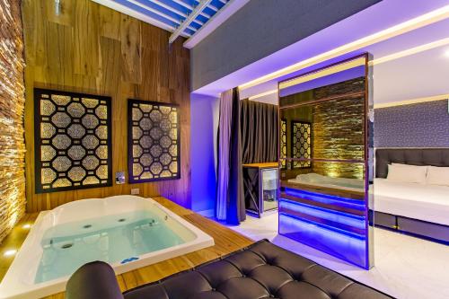 um quarto com uma banheira e uma cama em Drops Motel Brasília em Brasília