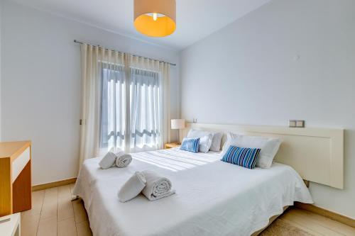 a bedroom with a large white bed with towels on it at One Bedroom Apartment in Albur Village 1A in Alvor