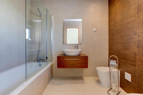 a bathroom with a sink and a toilet and a tub at One Bedroom Apartment in Albur Village 1A in Alvor