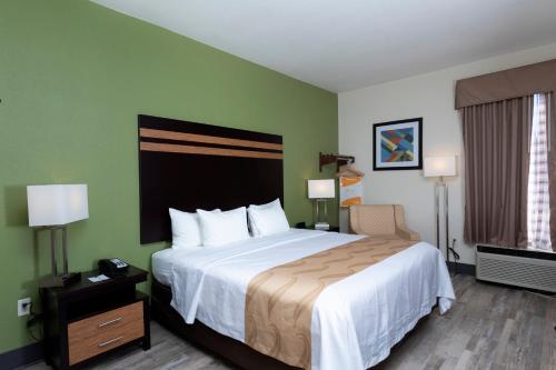 Cette chambre comprend un grand lit et une chaise. dans l'établissement Quality Inn & Suites, à Mount Vernon
