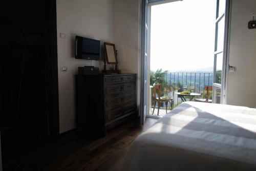 una camera con letto, TV e balcone di b&b cascina la cinciallegra a Oggiono