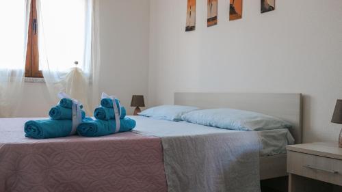 Un dormitorio con una cama con dos bolsas azules. en Baia, en Budoni