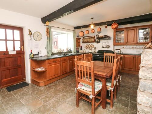 a kitchen with wooden cabinets and a wooden table and chairs at Harbour Cottage in Watchet