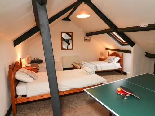 a bedroom with two beds and a green table at Harbour Cottage in Watchet