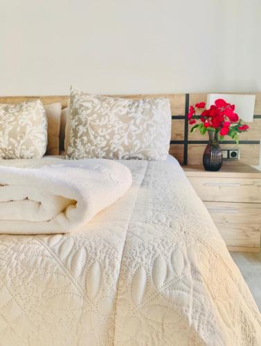 a bedroom with a white bed with a vase of flowers at Apartamentos “Quotidianum” in Úbeda