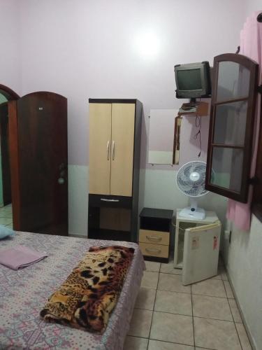 um quarto com uma cama, um espelho e uma televisão em Pousada Terra das Águas em São Lourenço
