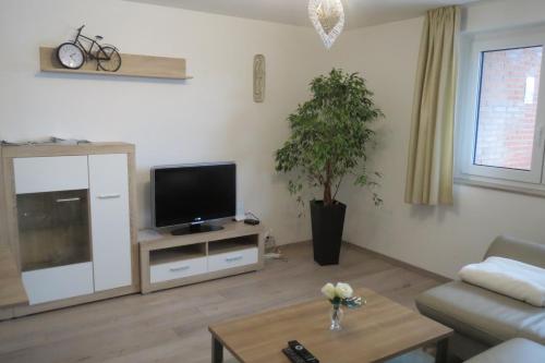 Una sala de estar con televisión y un sofá. en Chalet M, en Eupen