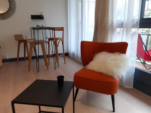un salon avec une chaise et une table dans l'établissement St Germain en Laye- La défense 17mn -STUDIO FIBRE -Terrasse, à Le Pecq