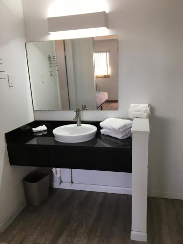 a bathroom with a sink and a mirror at Sands Motel in Van Horn
