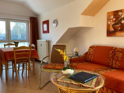 ein Wohnzimmer mit einem Sofa und einem Tisch in der Unterkunft Birnbaumhof - Hotel Pension und Ferienwohnungen in Schwedelbach