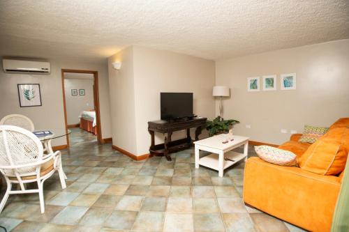 a living room with a couch and a tv and a table at Le Plaza Hotel in Port-au-Prince