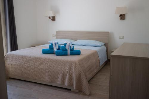 a bedroom with a bed with blue pillows on it at Incanto in Budoni