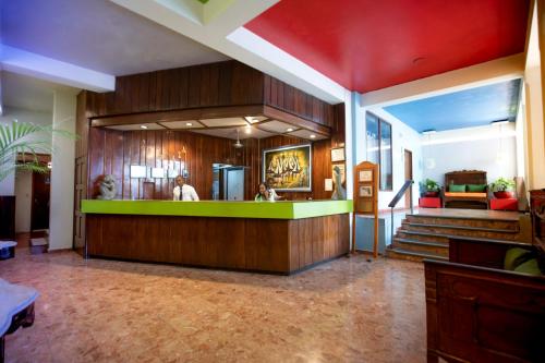 a lobby of a restaurant with a green counter at Le Plaza Hotel in Port-au-Prince