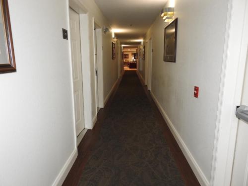 a long hallway with white walls and a long hallway with a long hallway at Inn at Cemetery Hill in Gettysburg