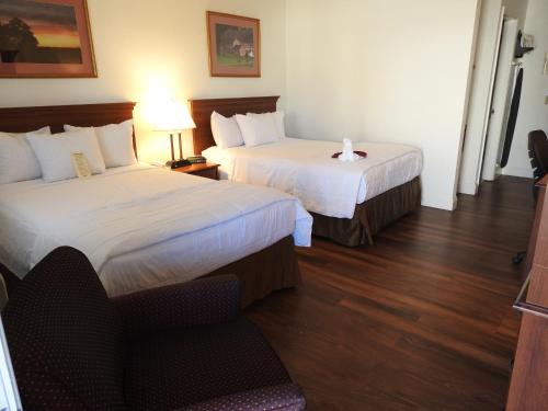a hotel room with two beds and a chair at Inn at Cemetery Hill in Gettysburg